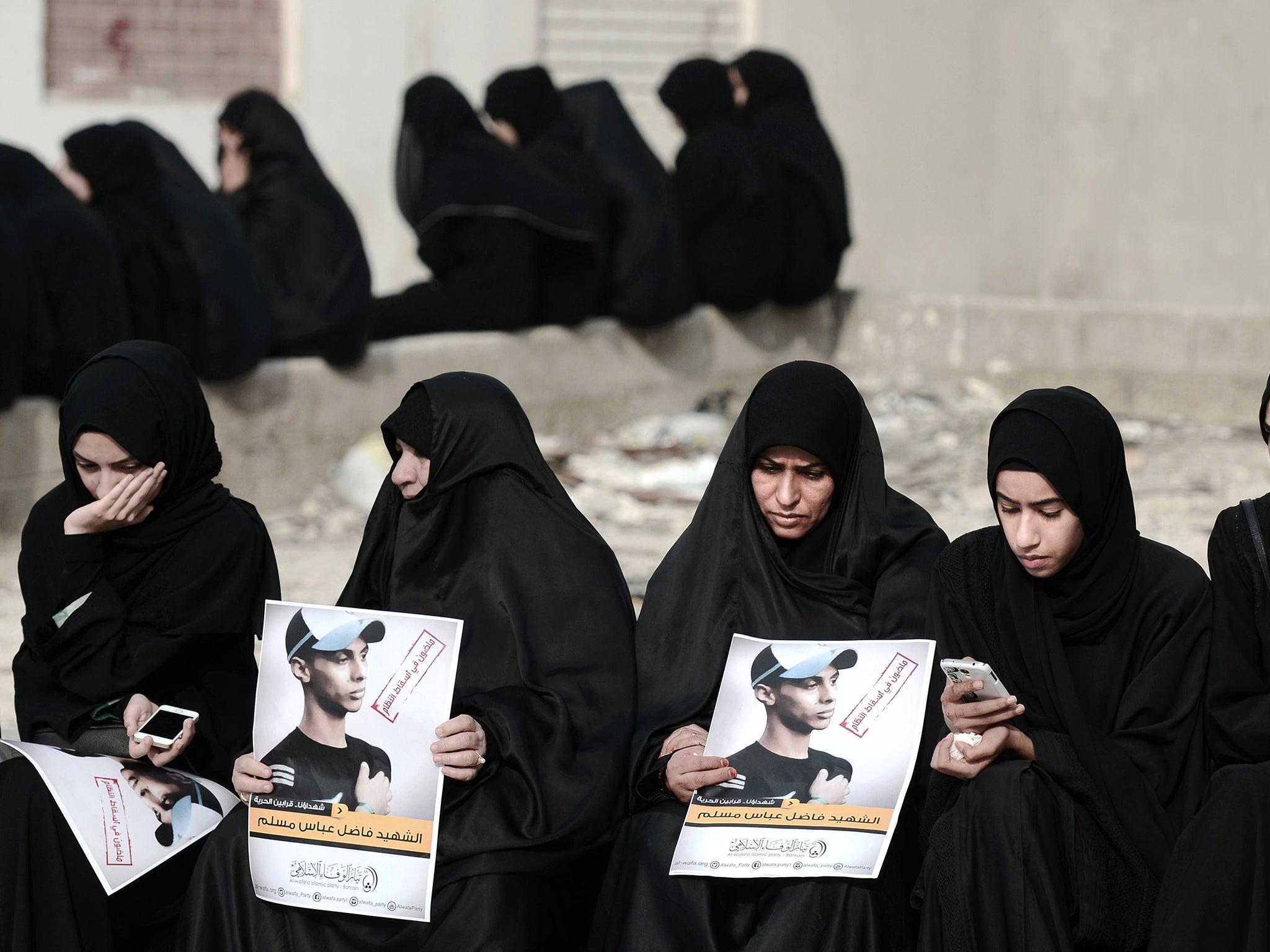 Bahraini Muslim Shiite Women hold pictures during an anti-government rally in solidarity with a victim of torture in 2012