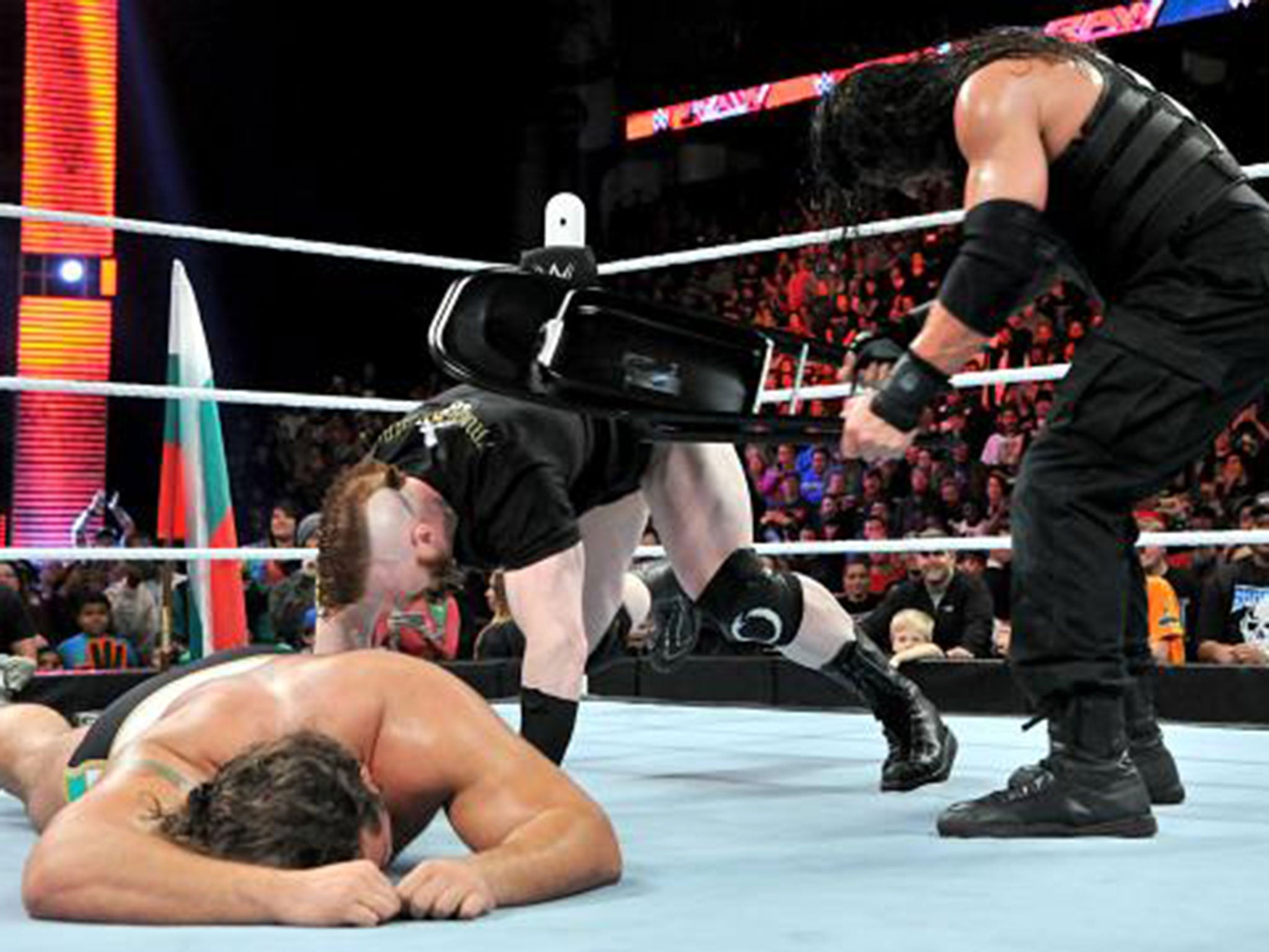 Roman Reigns hits Sheamus with a chair