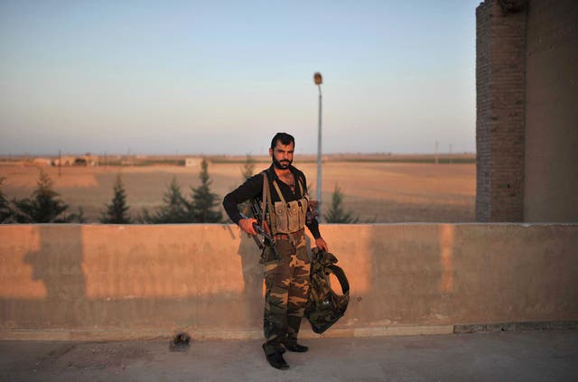 A Syrian Turkmen fighter on patrol on the terrace of a former agricultural school, abandoned by soldiers loyal to Syrian President Bashar al-Assad, Tel Abyad, 10 km from the Turkish-Syrian border