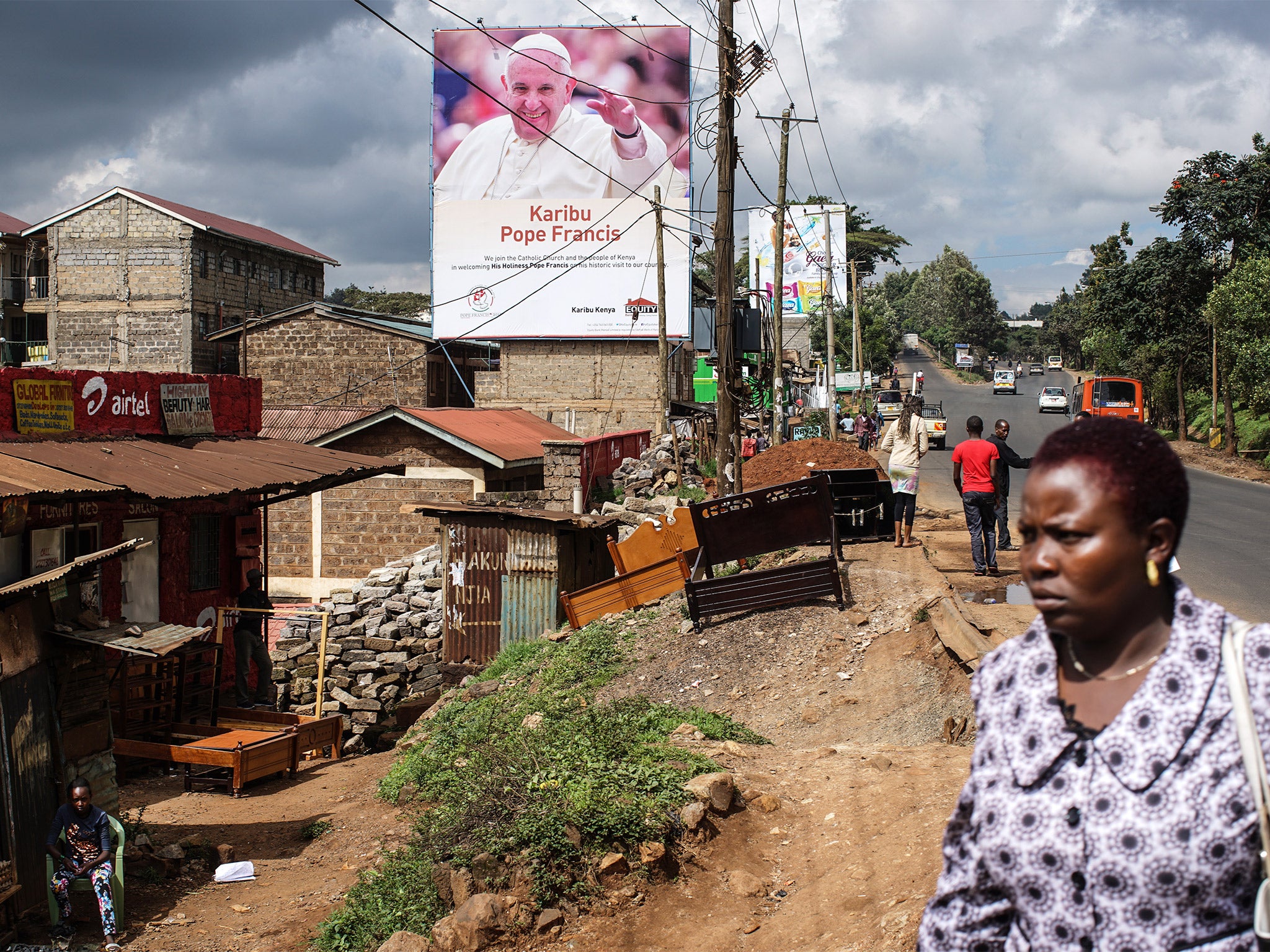 A poster in the Kangemi slum of Nairobi welcomes Pope Francis on his visit to Kenya. But campaigners want the pontiff to intervene over the unsolved killing of a Catholic missionary in 2000