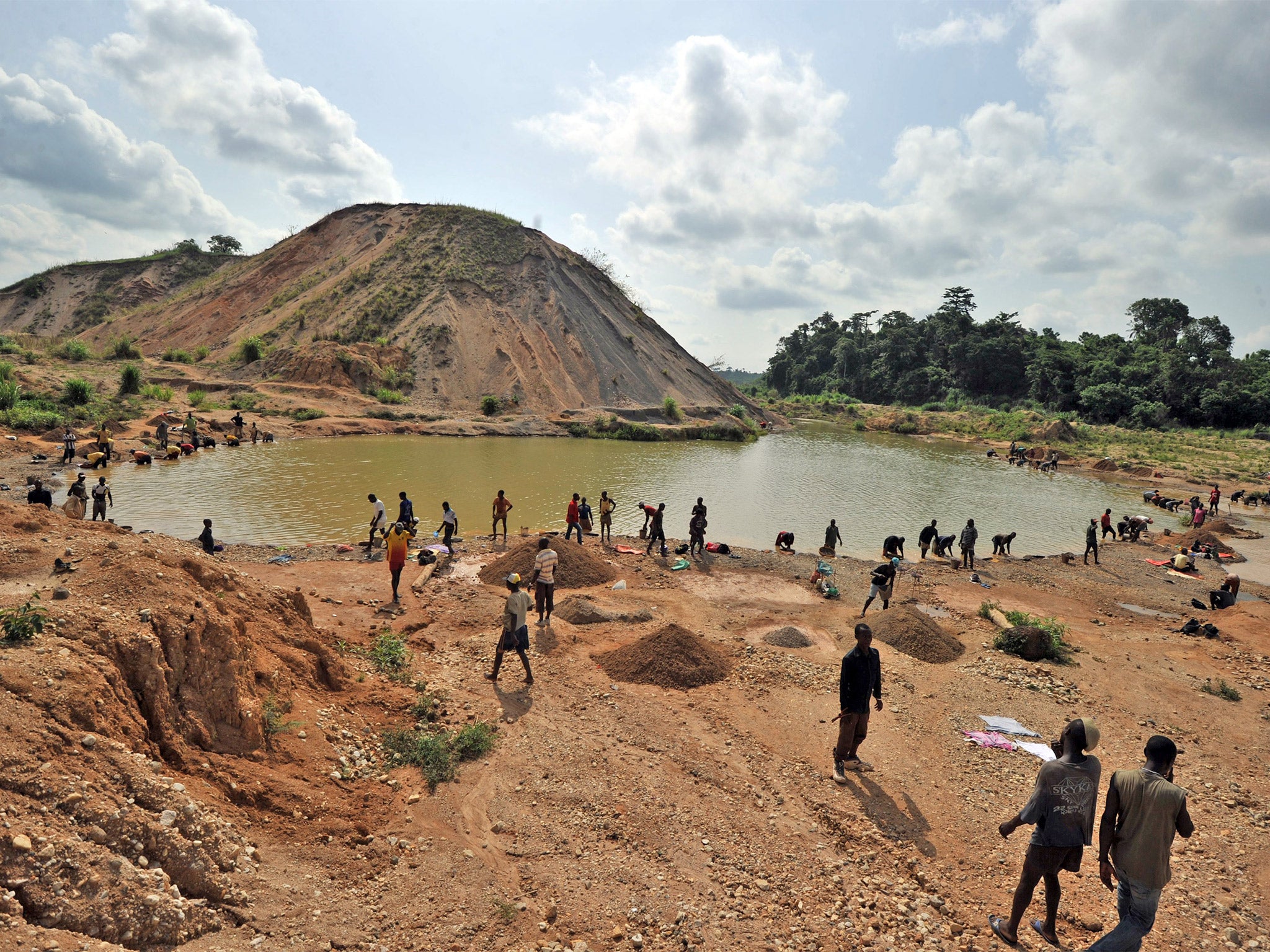 Diamond prospectors filter earth from a river in Koidu, where diamonds were discovered in 1930