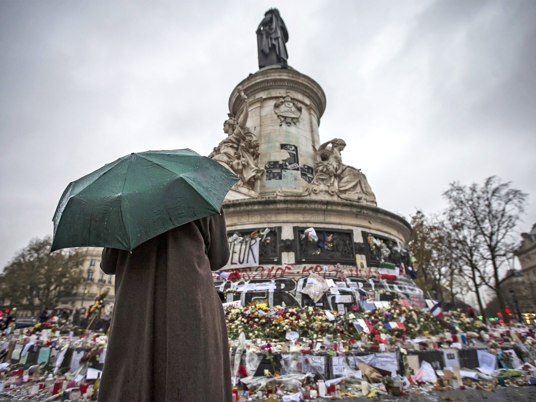 The makeshift shrine of candles and flowers for the victims of last week’s Paris attacks in Place de la Republique