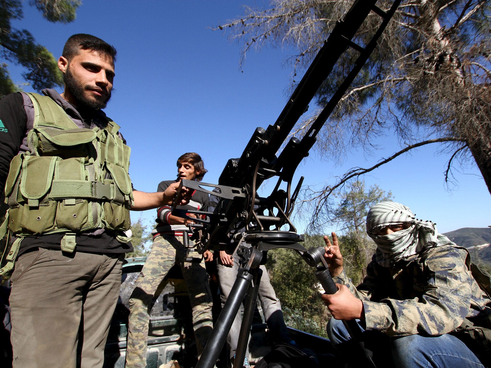 Syrian Turkmen fighters are seen with an anti-aircraft artillery weapon near the northern Syrian village of Yamadi on 24 November 2015