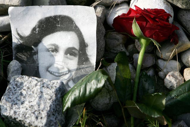 A picture of Anne Frank lies in front of her memorial stone