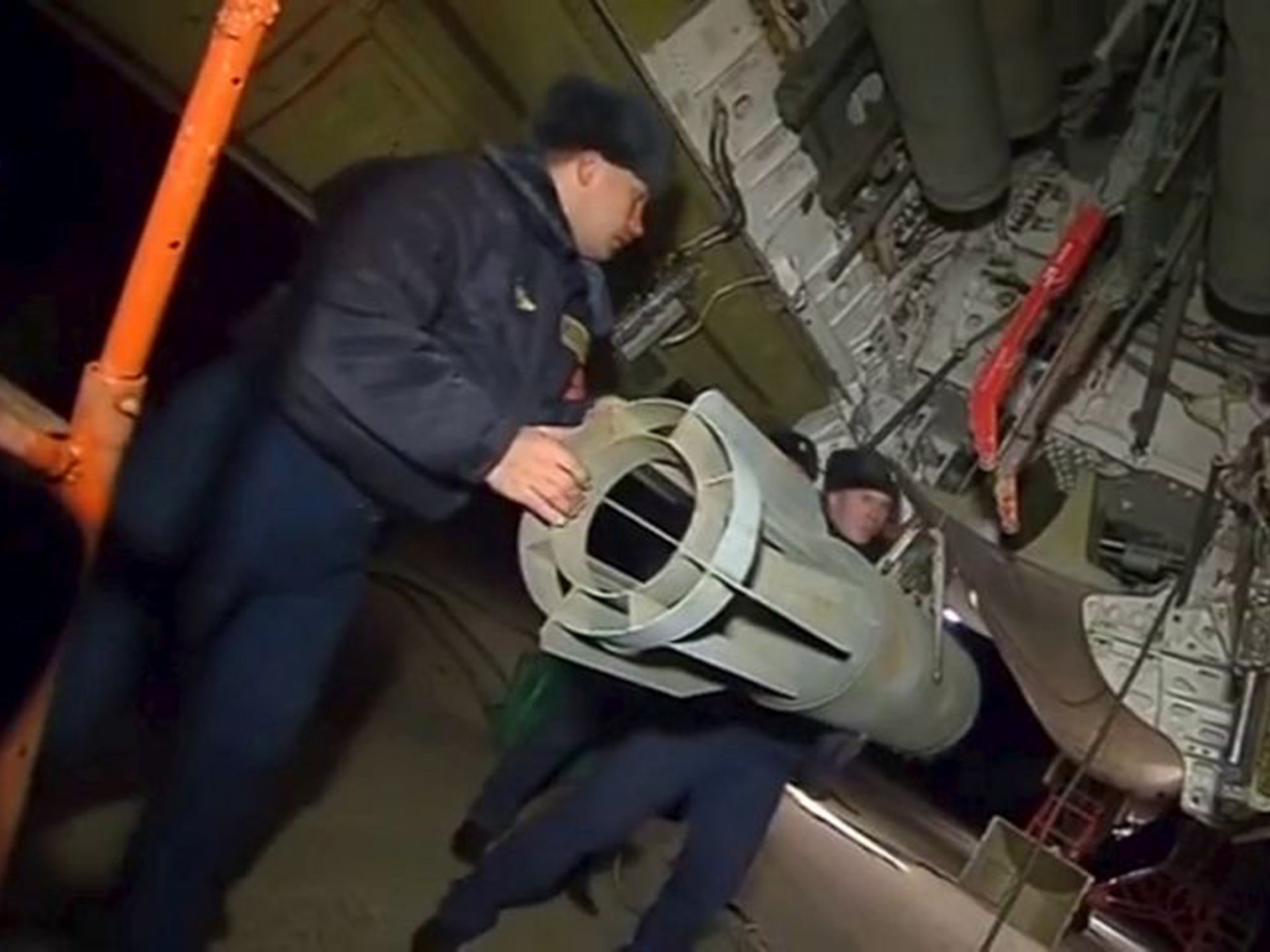 Russian ground staff members loading a long-range bomber with weapons