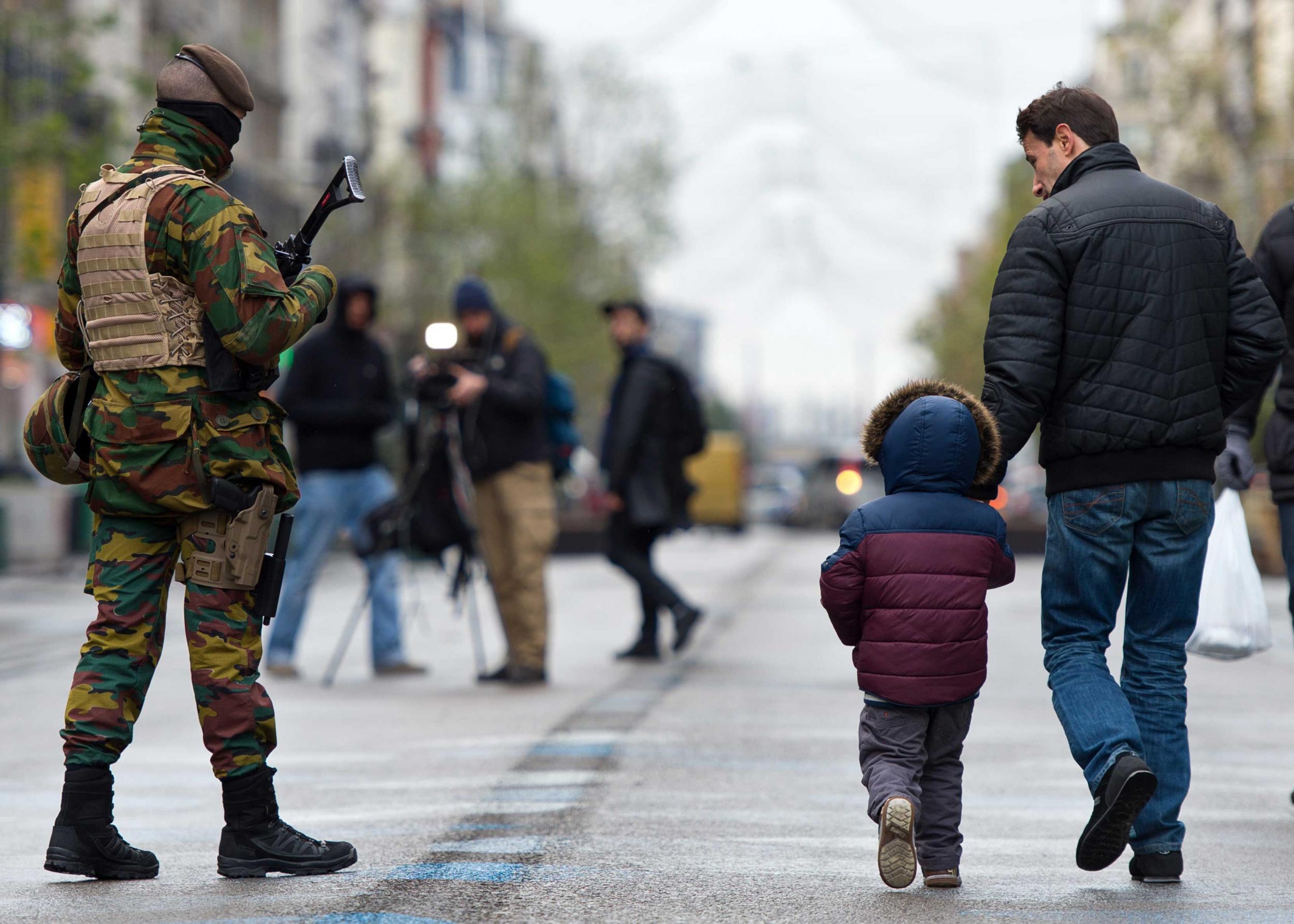 Brussels has been under a security lockdown amid a manhunt for one of the suspected Paris attackers