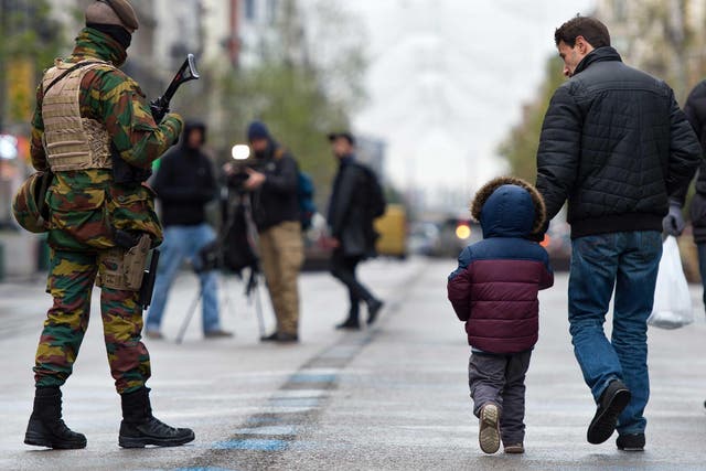 Brussels has been under a security lockdown amid a manhunt for one of the suspected Paris attackers