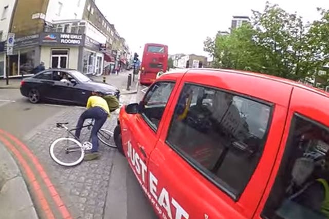 A cyclist is knocked off his bike after attempting to undertake a black cab in London