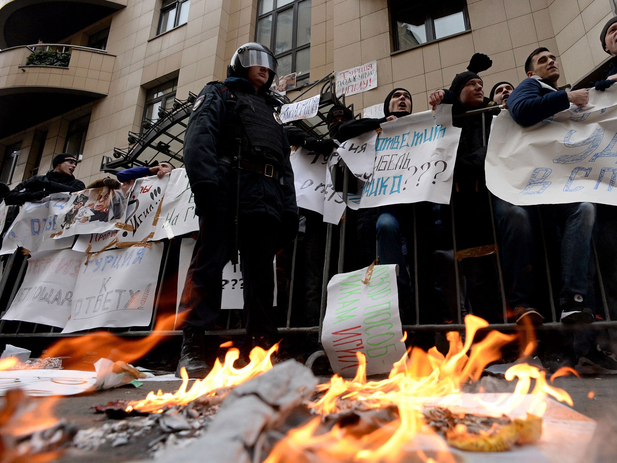 Protesters hold placards and shout slogans as they take part in an anti-Turkey picket outside the Turkish embassy in Moscow on November 25, 2015.