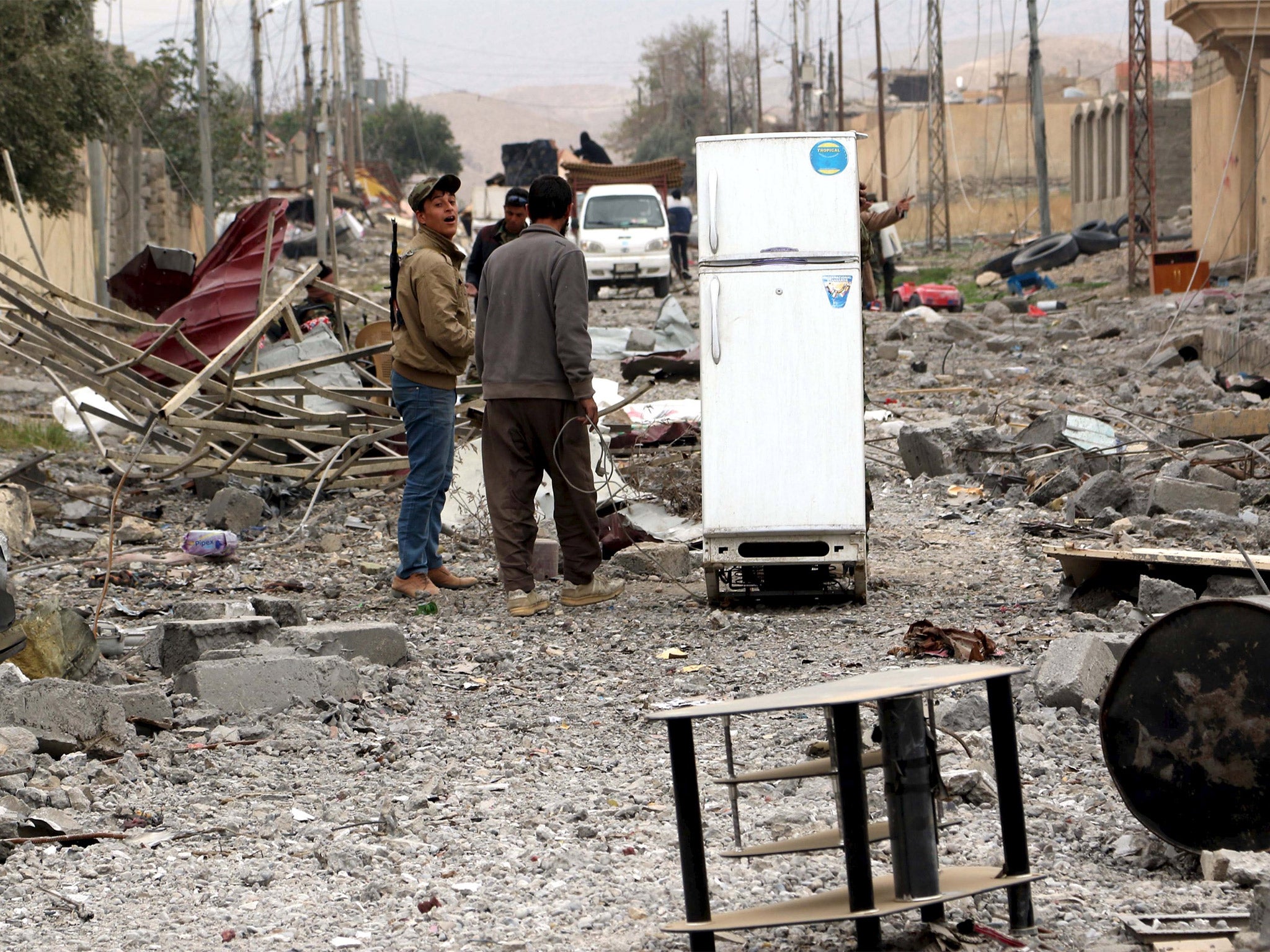 Yazidis loot goods from abandoned houses in Sinjar after a Kurdish force expelled Isis earlier this month