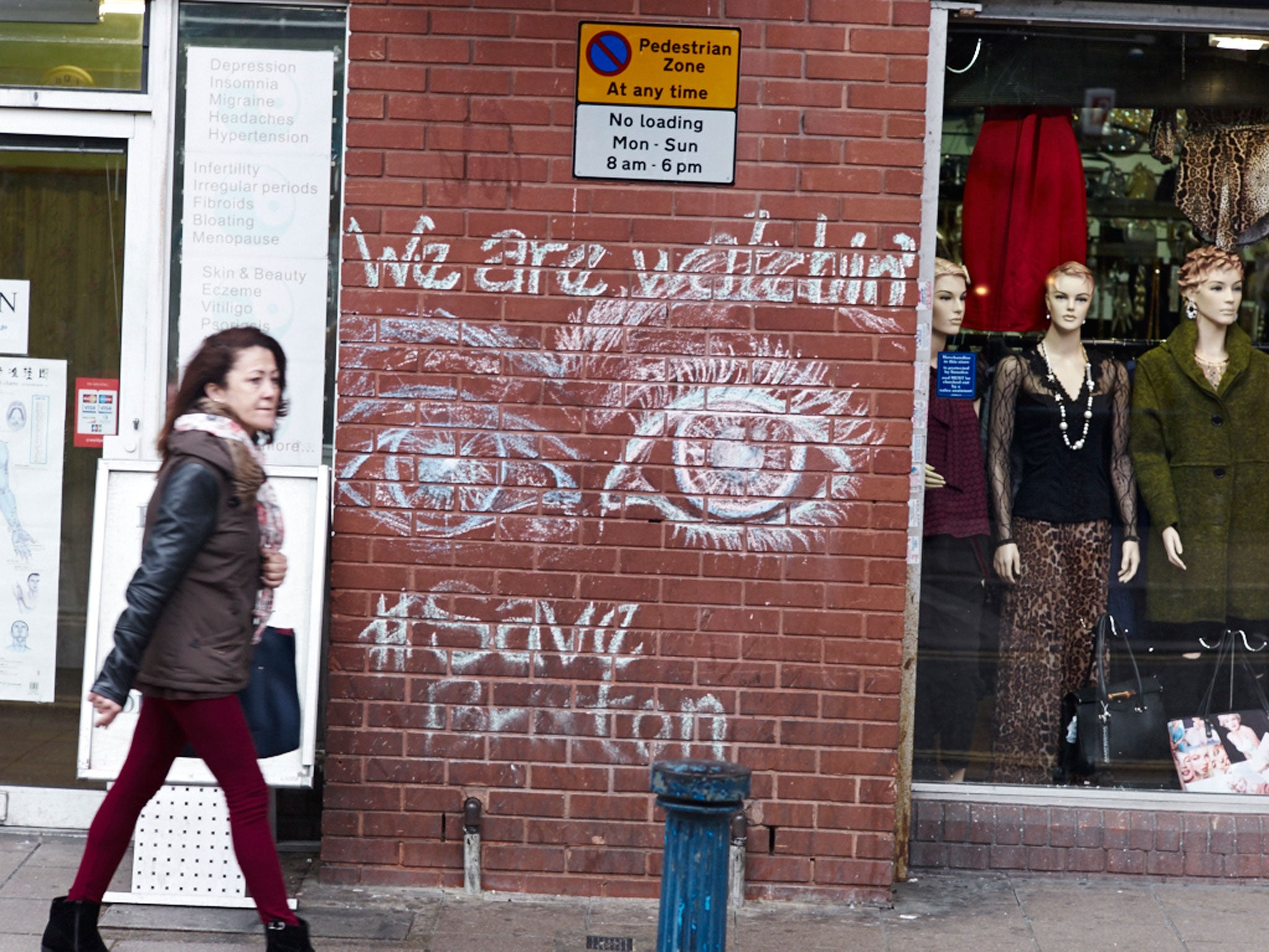 Writing on the wall: A woman walks past 'Save Brixton' graffiti
