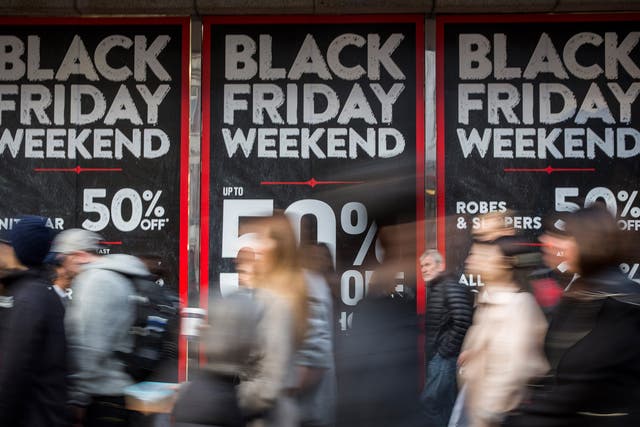 People walk past a shopfront on Oxford Street advertising 'Black Friday' discounts in London
