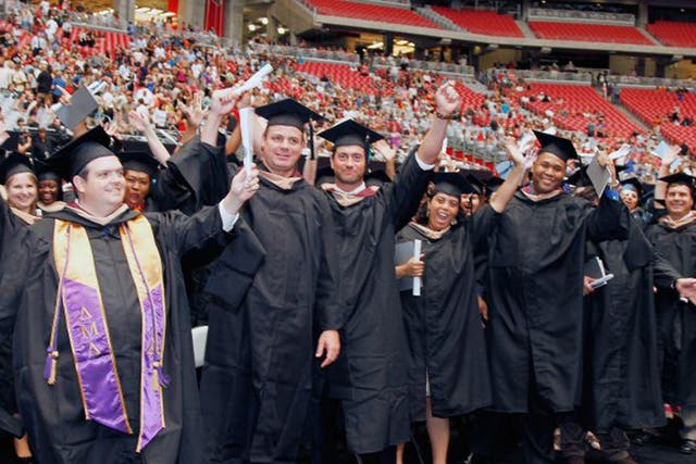 Students show their excitement  during the graduation ceremony for the University of Phoenix at the Arizona Cardinals stadium