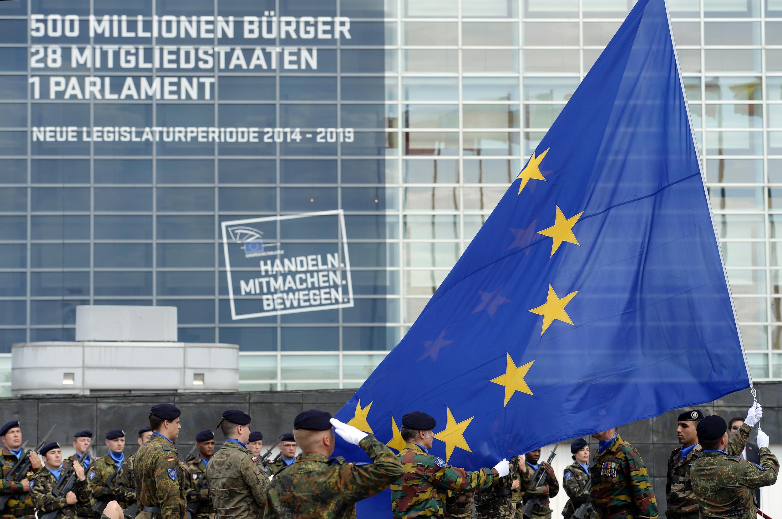 Soldiers of a Eurocorps detachment raise the European Union flag to mark the inaugural European Parliament session on June 30, 2014