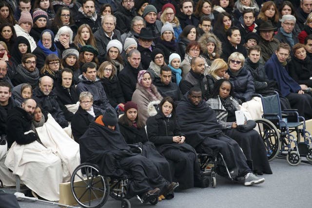 Wheelchair-bound victims sit with the relatives of the 130 killed in the Paris attacks