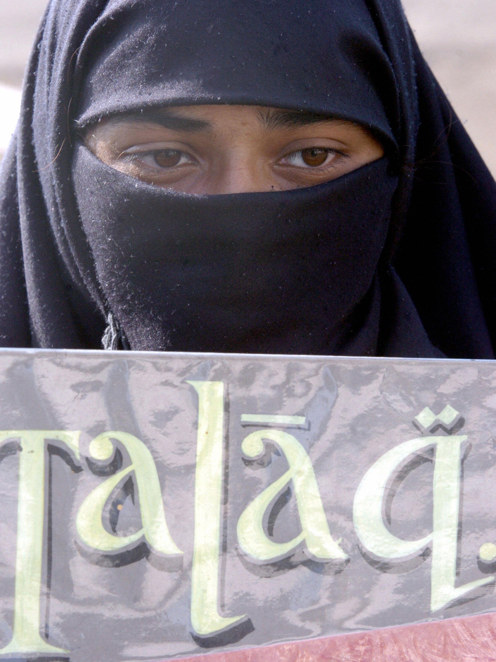 An Indian Muslim girl stands with a poster denouncing Talaq on International Women's Day in Bombay Getty