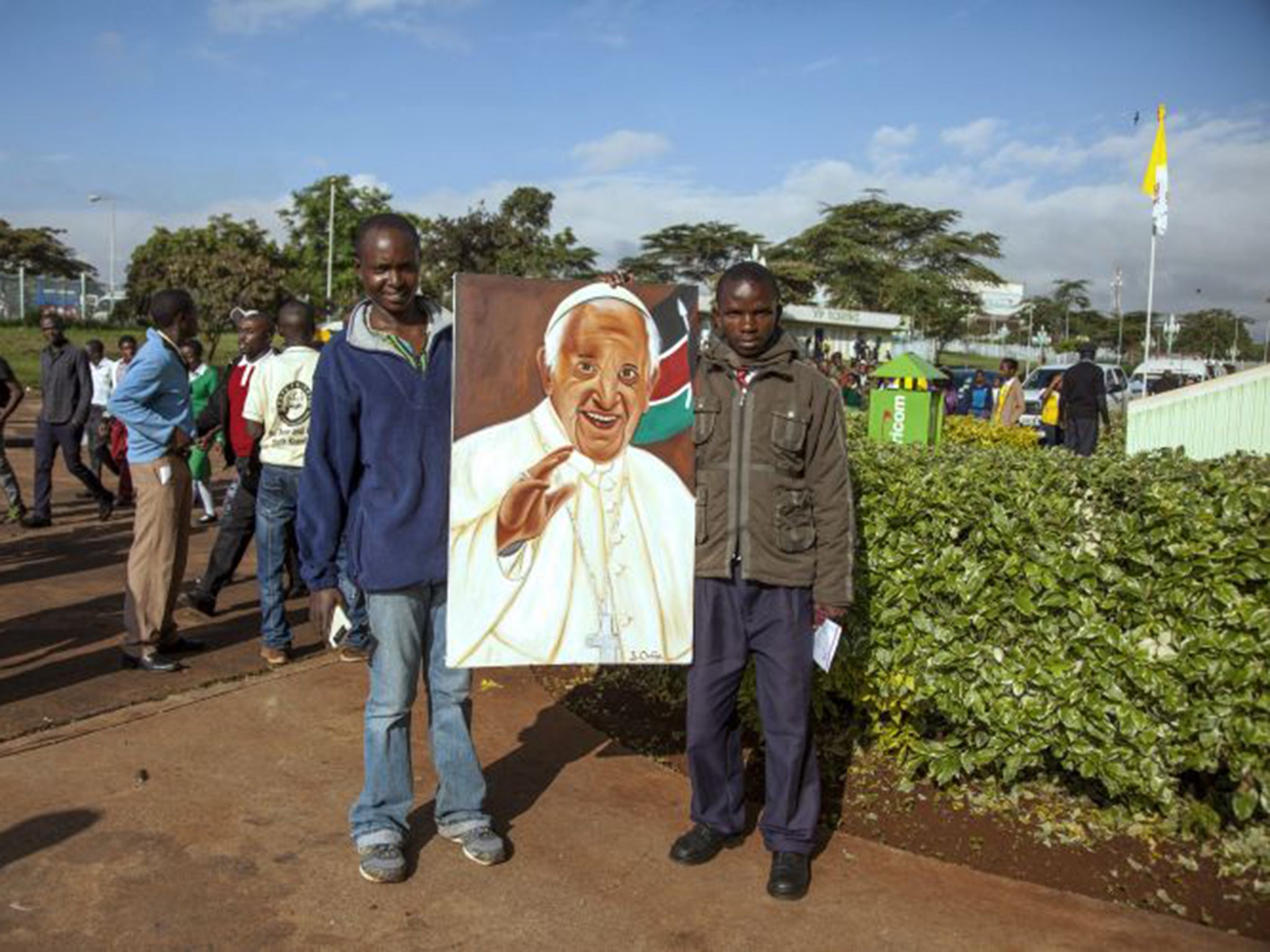 Men holds a portrait of Pope Francis as they gather at the Kasarani Sport Stadium in Nairobi on November 27, 2015