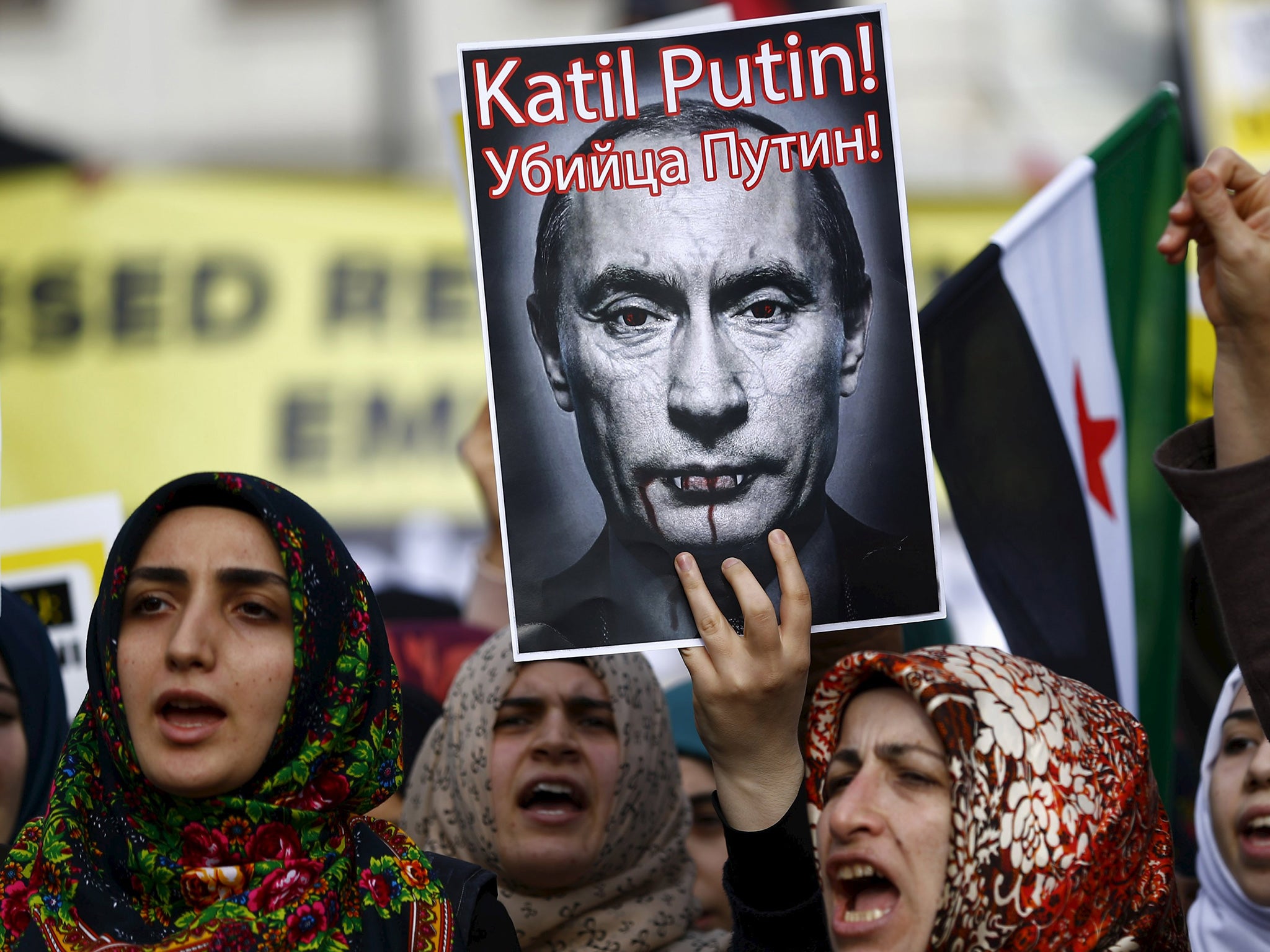Demonstrators hold a defaced poster of Vladimir Putin – branded ‘a killer’ – at an anti-Russian protest in Istanbul yesterday