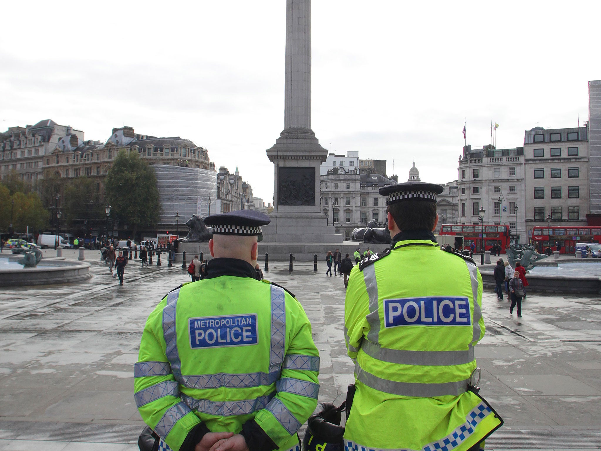 Policemen stand overlooking Trafalgar Square in London on November 9, 2011