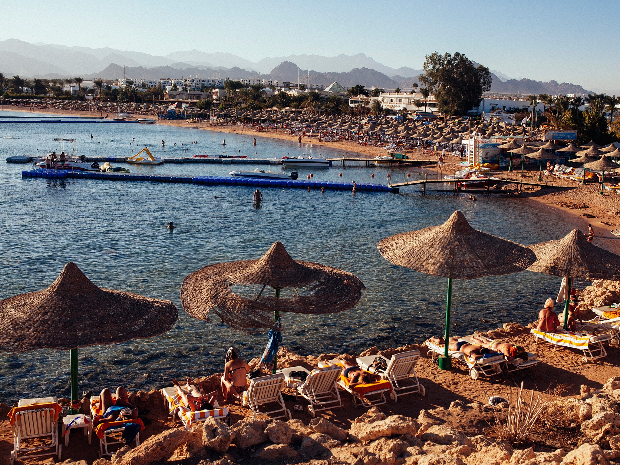 People relax on beach chairs at a beach in the Red Sea resort town of Sharm El Sheikh