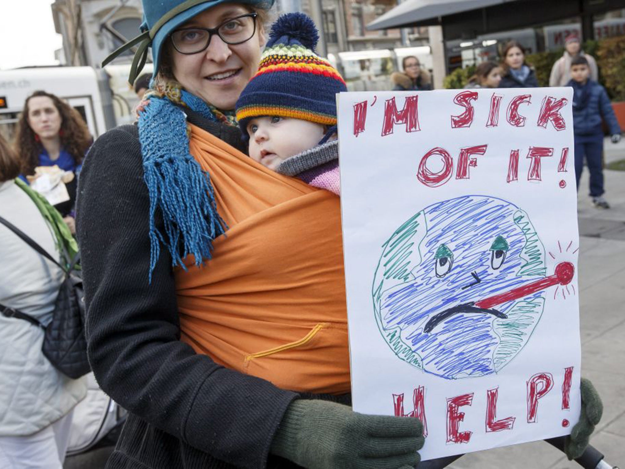 A woman holds a banner at the Global Climate March in Geneva, Switzerland, 28 November 2015