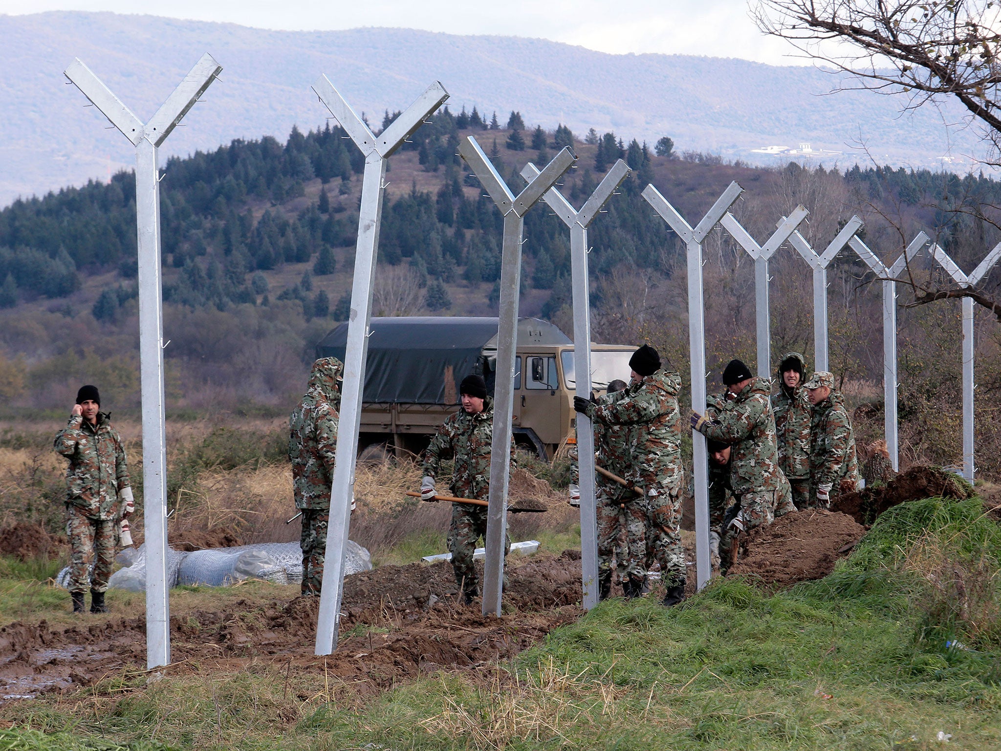 Macedonian soldiers build a metal fence at the Greek-Macedonian border