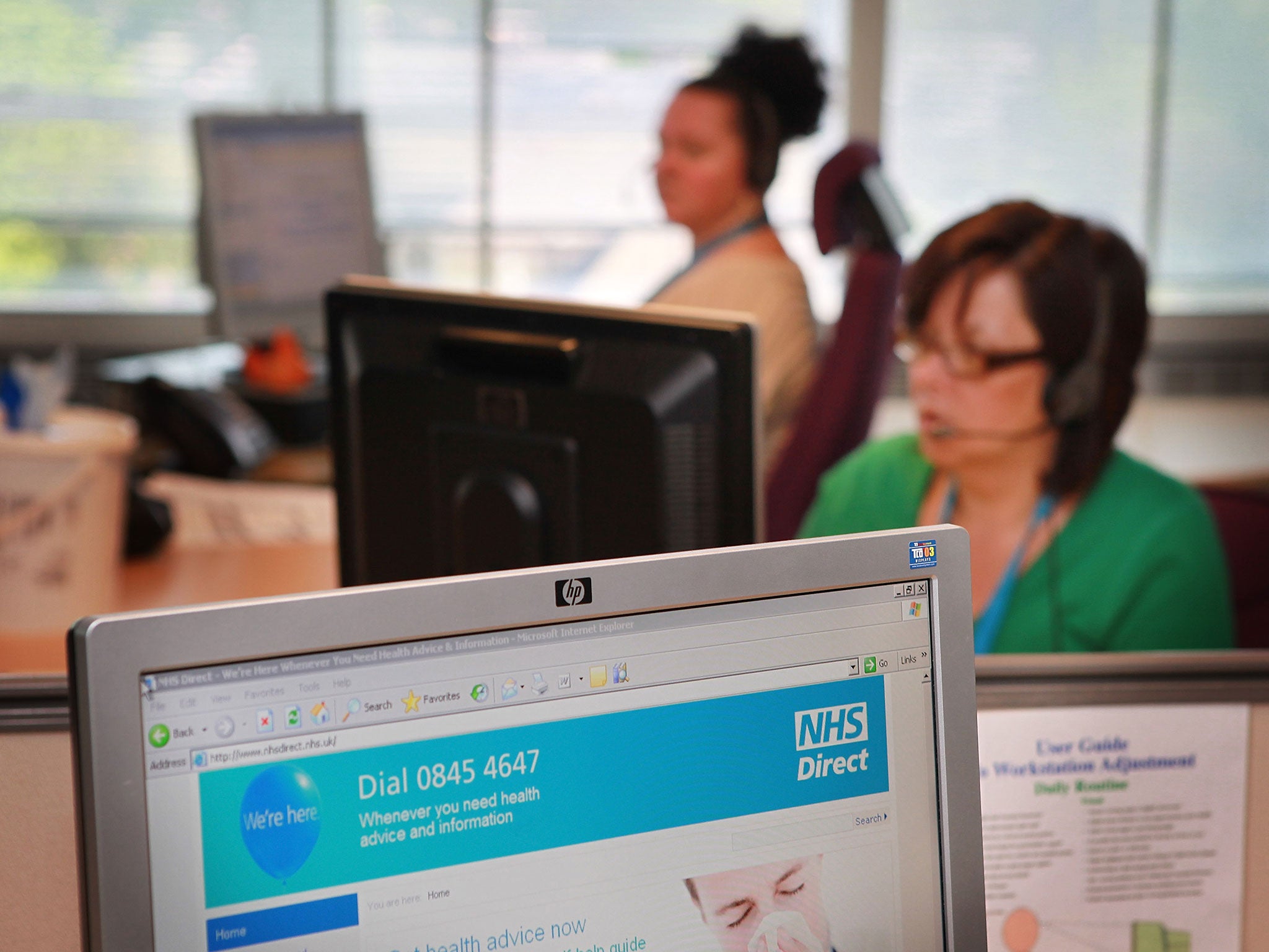 Workers take calls at a National Health Service call centre