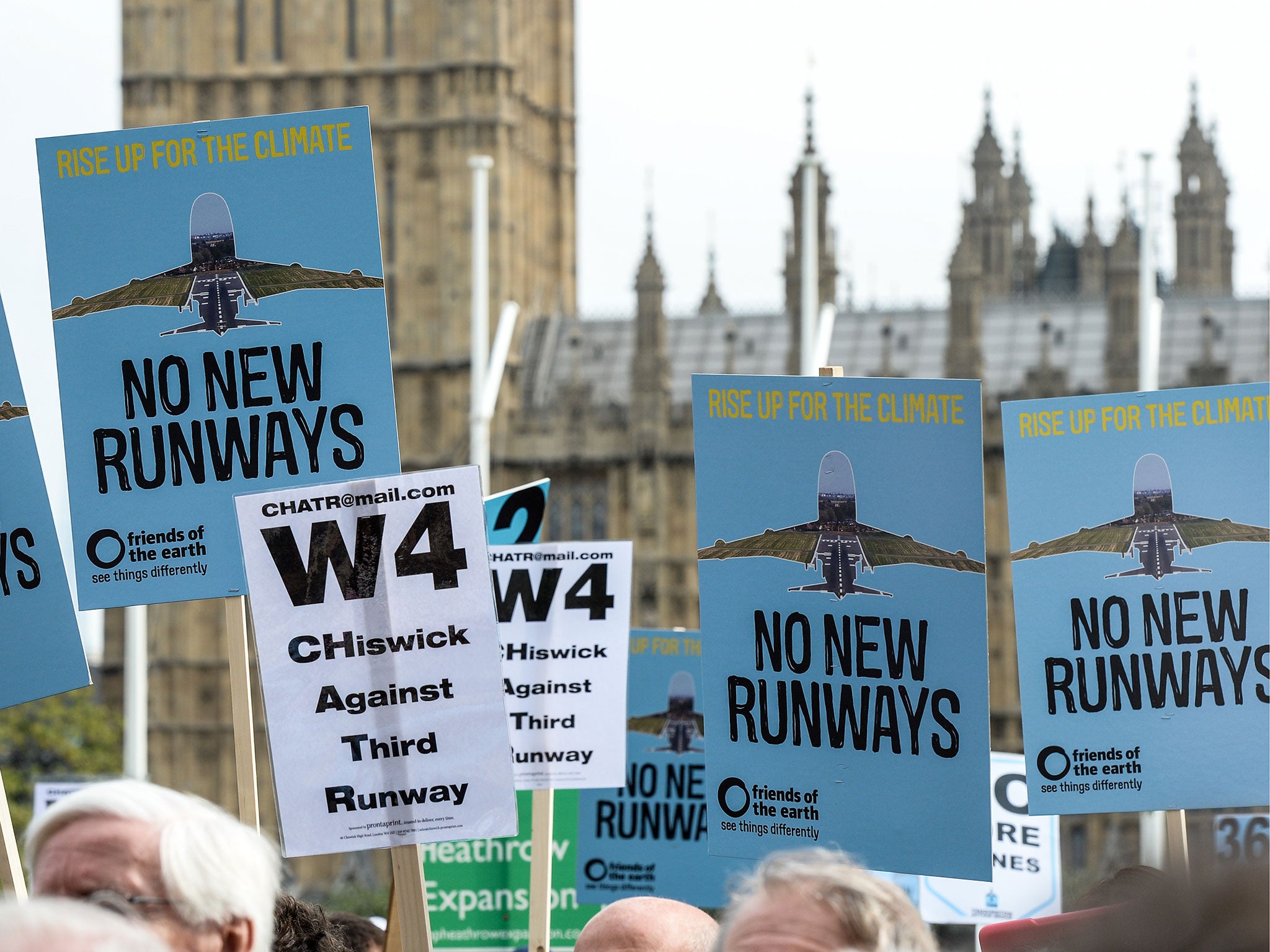 Protesters hold signs during a rally against a third runway at Heathrow airport, in Parliament Square