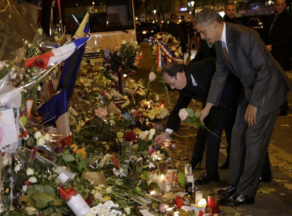 U.S. President Barack Obama and French President Francois Hollande pay their respect at the Bataclan concert hall, one of the deadly Paris attack sites, after Obama arrived in the French capital to attend the World Climate Change Conference 2015