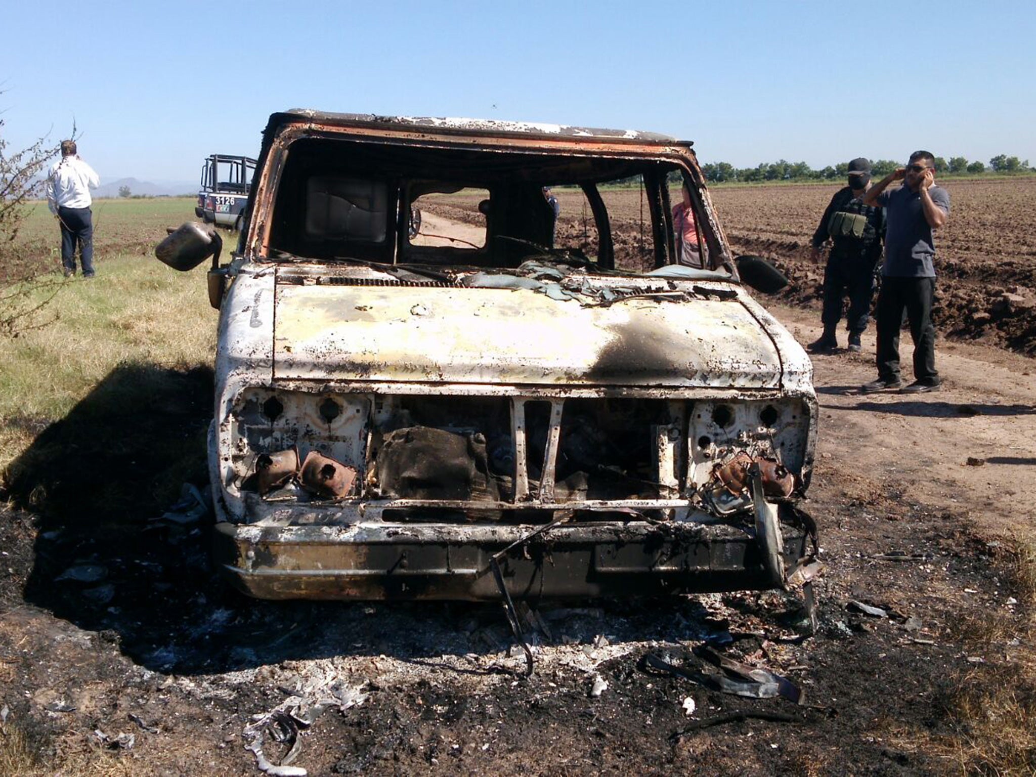 Mexican authorities inspect a burnt out van suspected to belong to a pair of Australian tourists missing for more than a week, in Sinaloa, Mexico