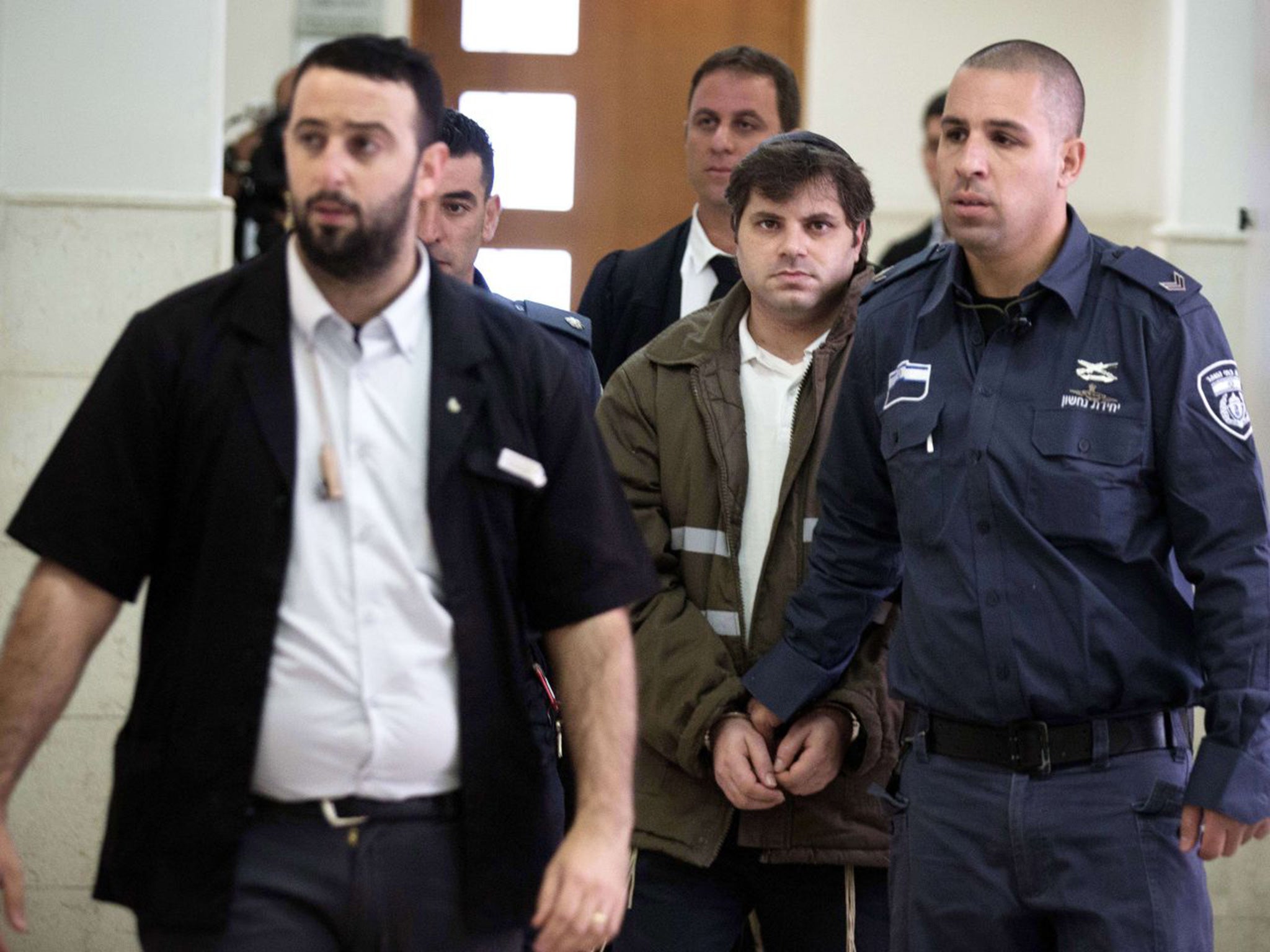 Yosef Haim Ben-David (C) is escorted by Israeli policemen at the district court in Jerusalem on November 30, 2015