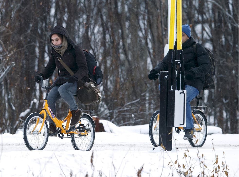 Two refugees on bikes cross the boarder between Norway and Russia