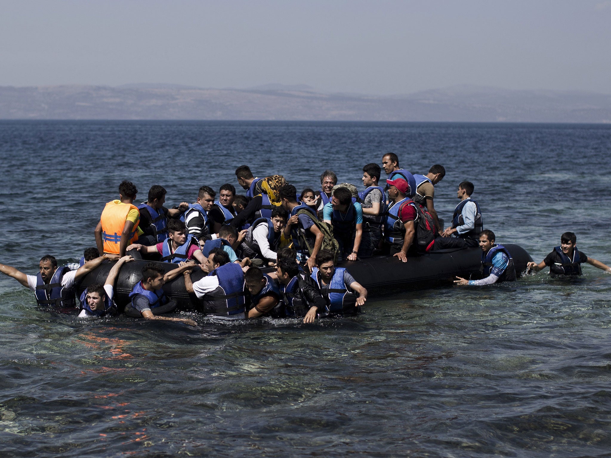 Syrian refugees arrive on the shores of the Greek island of Lesbos after crossing the Aegean Sea from Turkey on a inflatable dinghy on 11 September, 2015