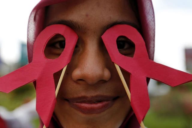 An AIDS activist holds a HIV sign on a rally campaign as they mark the World AIDS Day in Indonesia