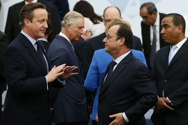 Britain's Prime Minister David Cameron (L) speaks with French President Francois Hollande (C) as they arrive for the family picture at the COP21 World Climate Change Conference in Paris