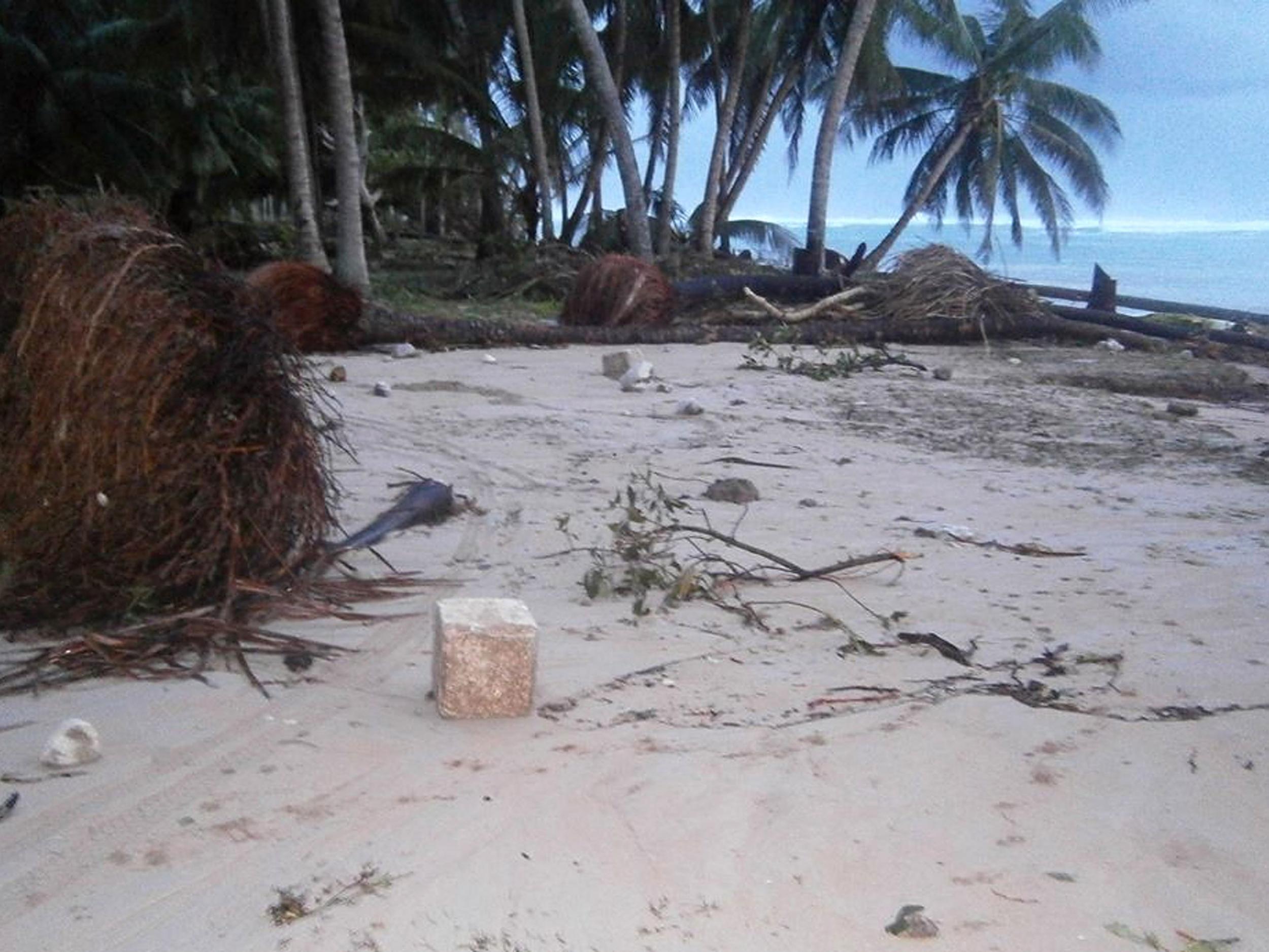 A beach littered with debris from a storm surge on the island of Tuvalu