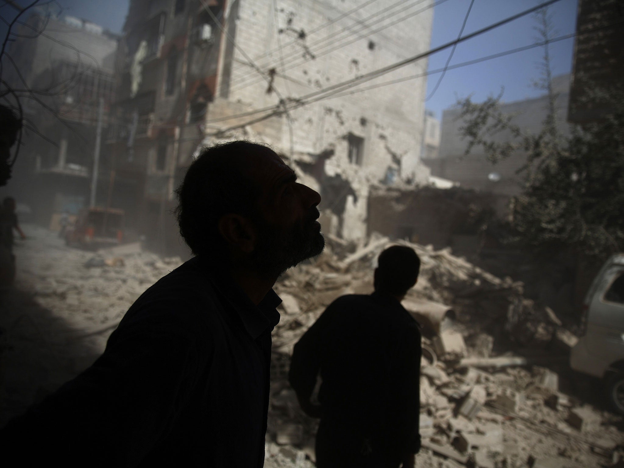 A Syrian civilian looks at the devastation in rebel-held territory