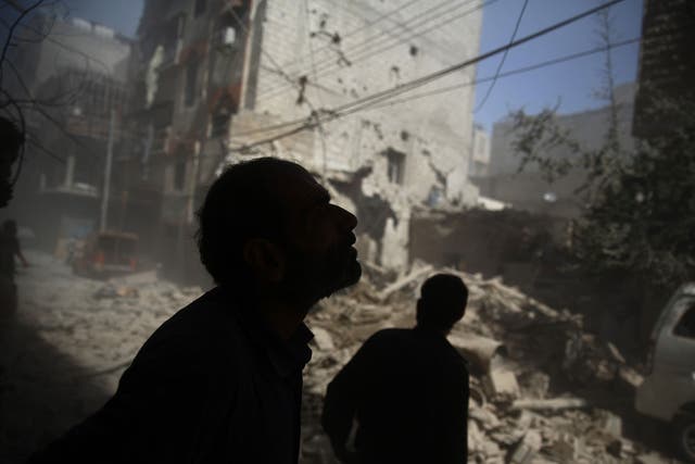 A Syrian civilian looks at the devastation in rebel-held territory