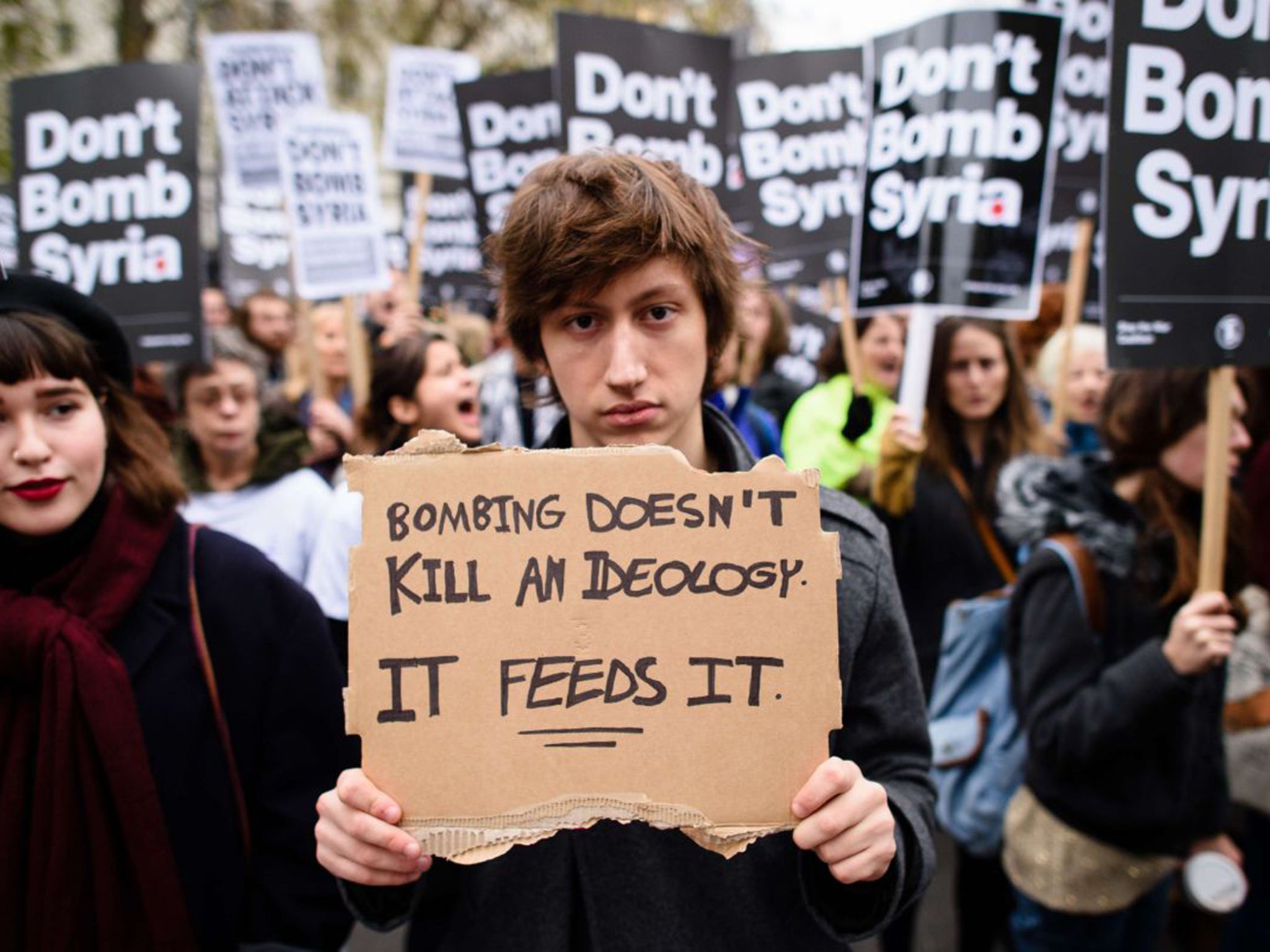 Demonstrators hold placards as they protest against the British government's proposed involvement in air strikes against the Isis