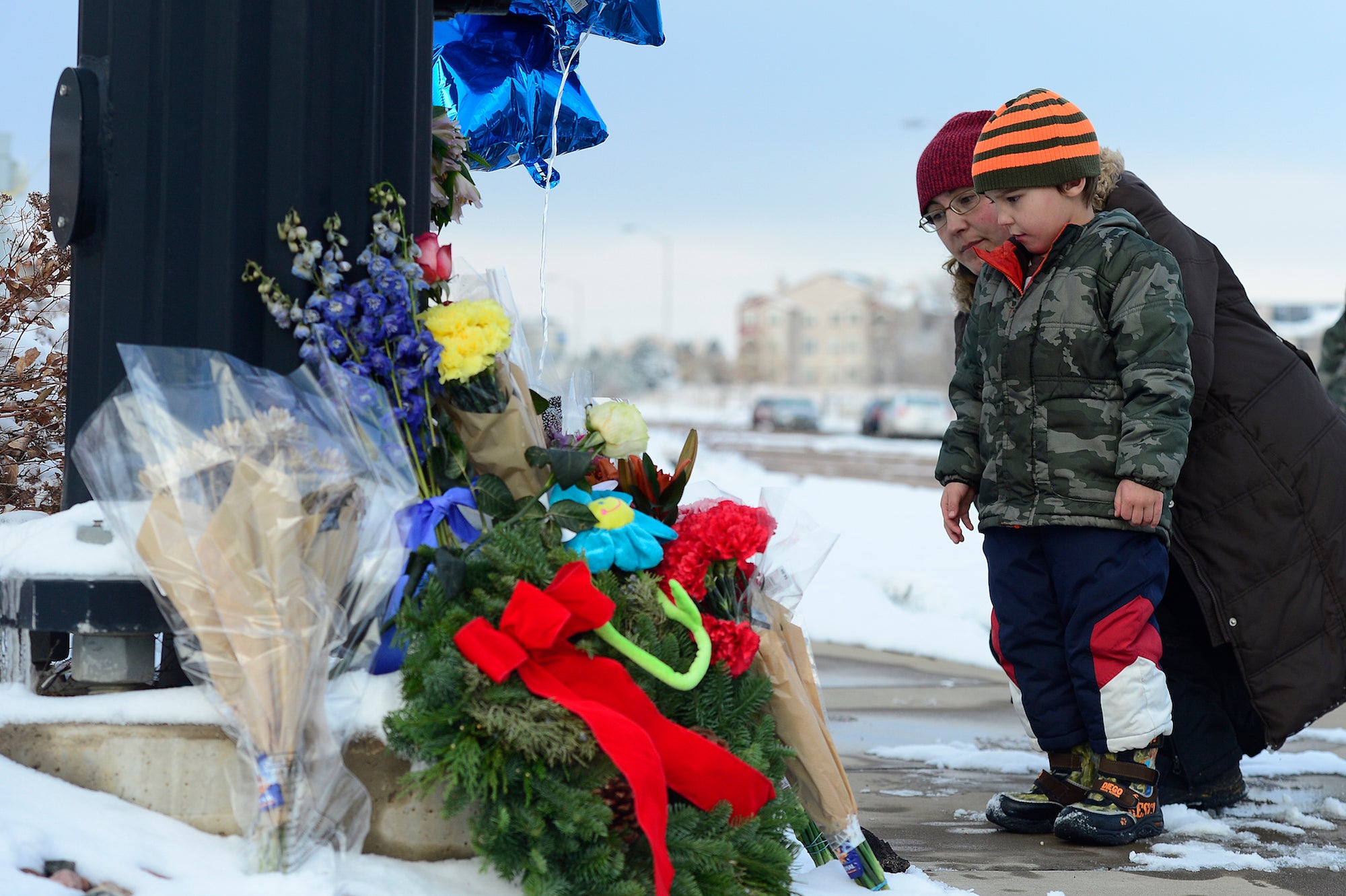 A man and his son visit a memorial for the shooting victims in Colorado Springs, Colorado.