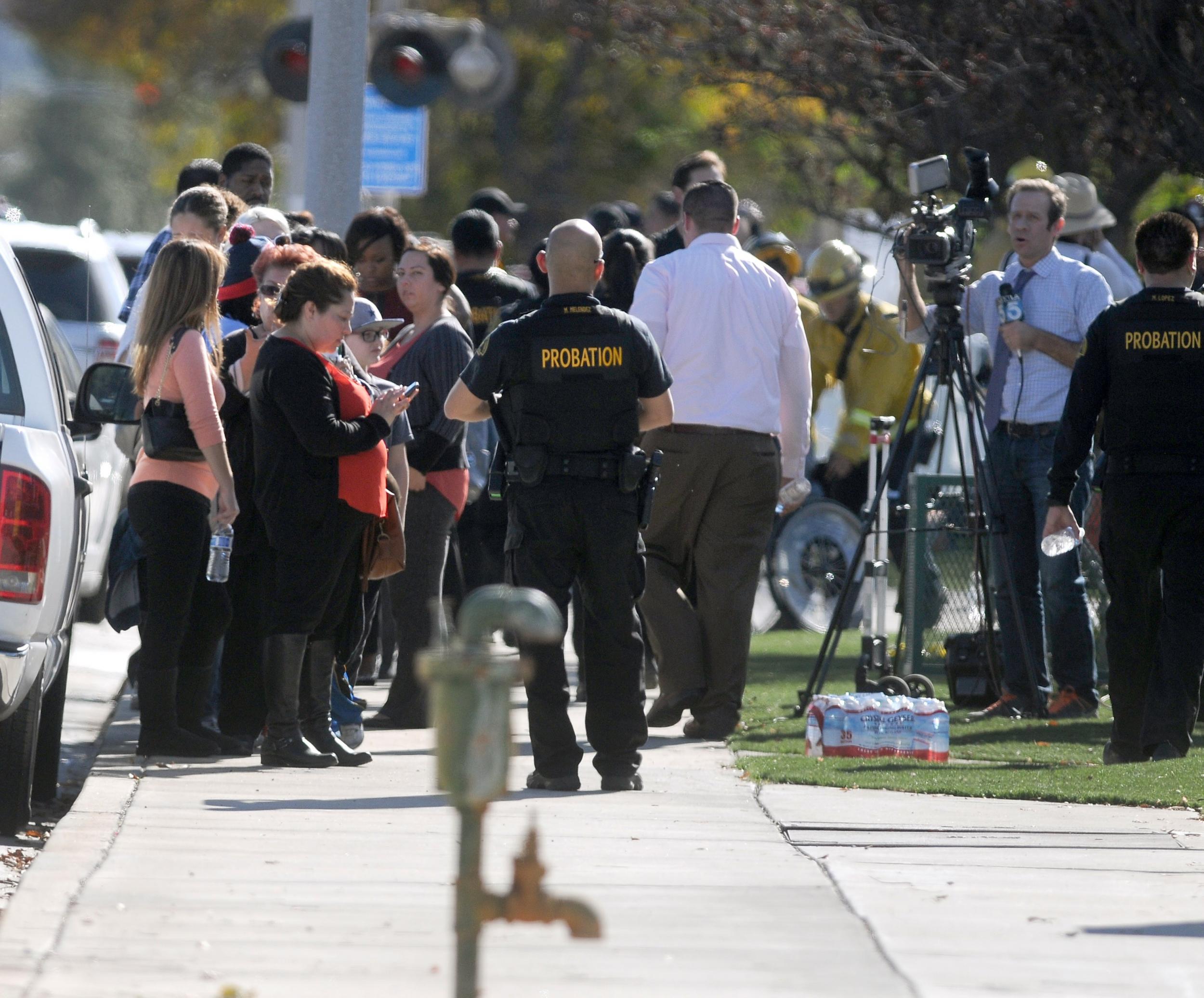 Police escort people from the building after the shooting