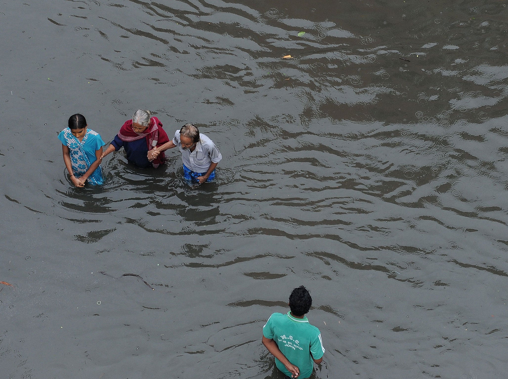 In this photograph taken on December 2, 2015, Indian people wade through floodwaters in Chennai