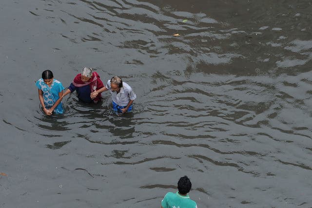 In this photograph taken on December 2, 2015, Indian people wade through floodwaters in Chennai