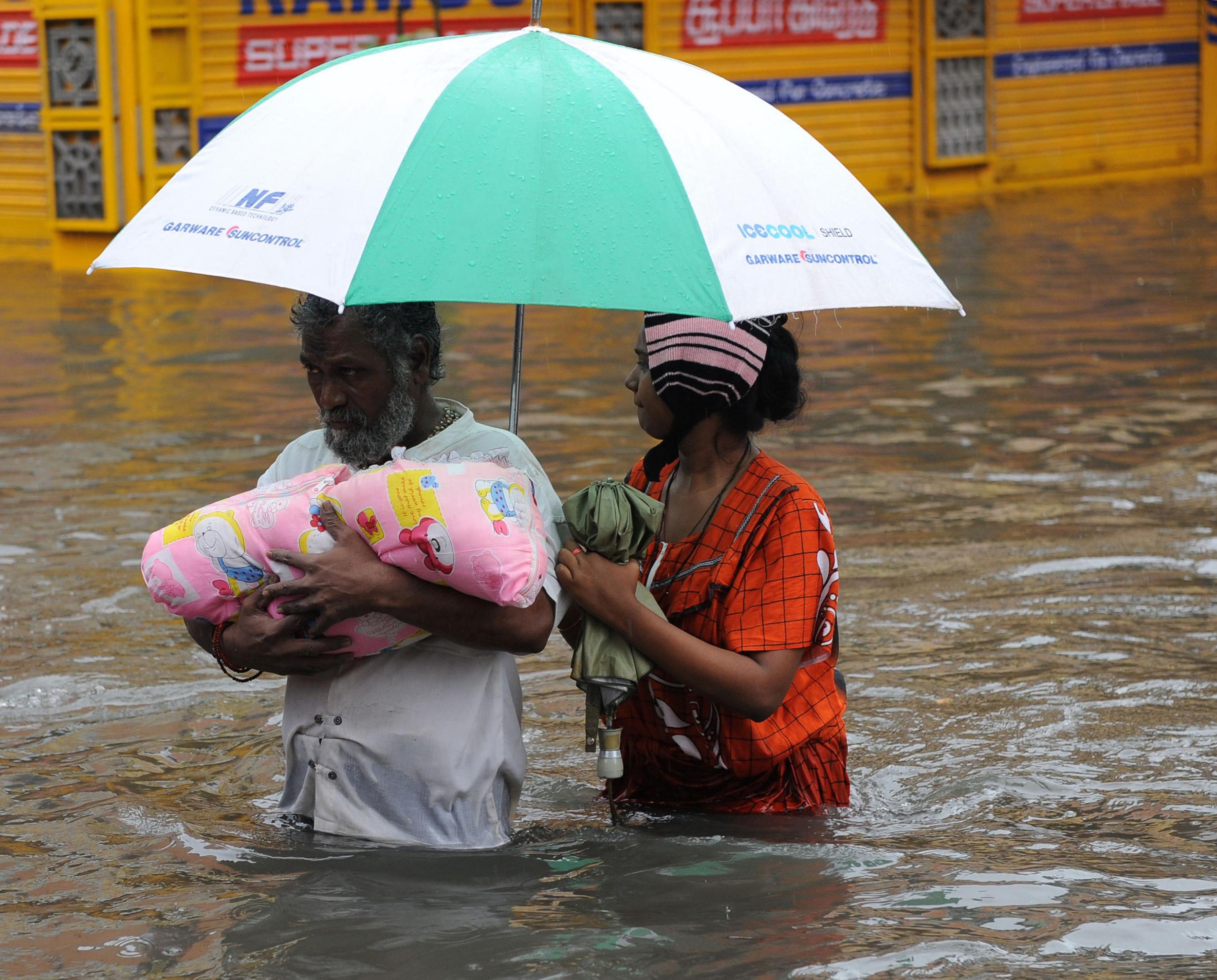 An Indian family wade through the flood waters in Chennai