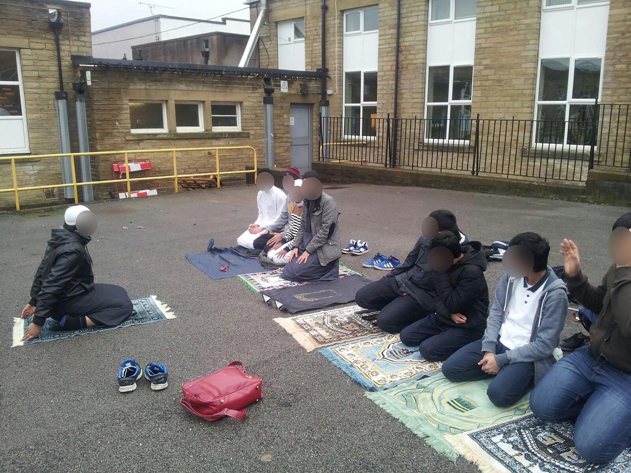 Children pray outside the Mirfield Free Grammar School and Sixth Form in Mirfield, West Yorkshire