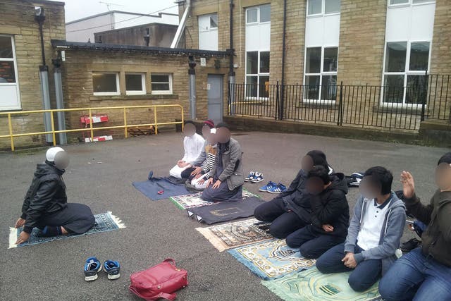 Children pray outside the Mirfield Free Grammar School and Sixth Form in Mirfield, West Yorkshire