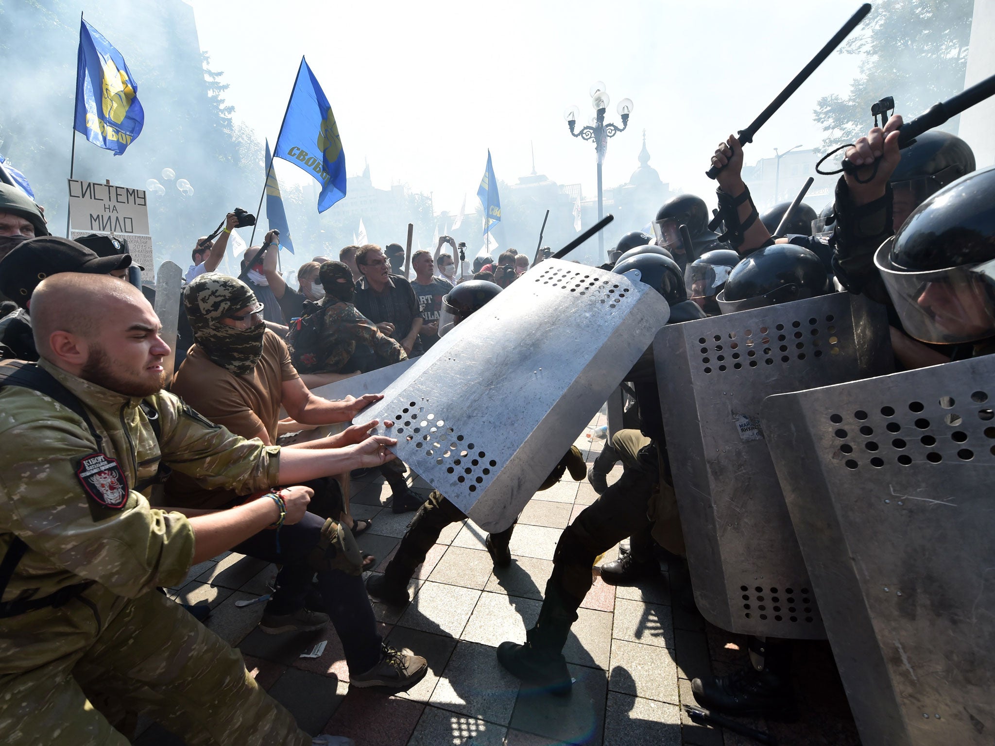 Fractured society: uniformed Ukrainian nationalist activists clash with police officers in front of the parliament in Kiev in August this year
