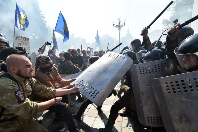 Fractured society: uniformed Ukrainian nationalist activists clash with police officers in front of the parliament in Kiev in August this year