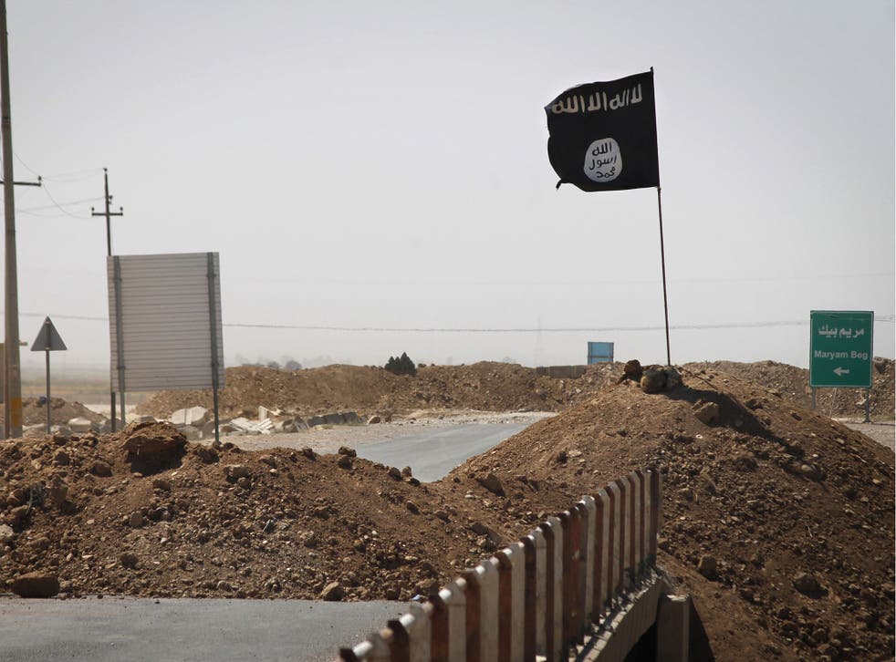 A flag of the Islamic State (Isis) is seen on the the frontline of fighting in Iraq
