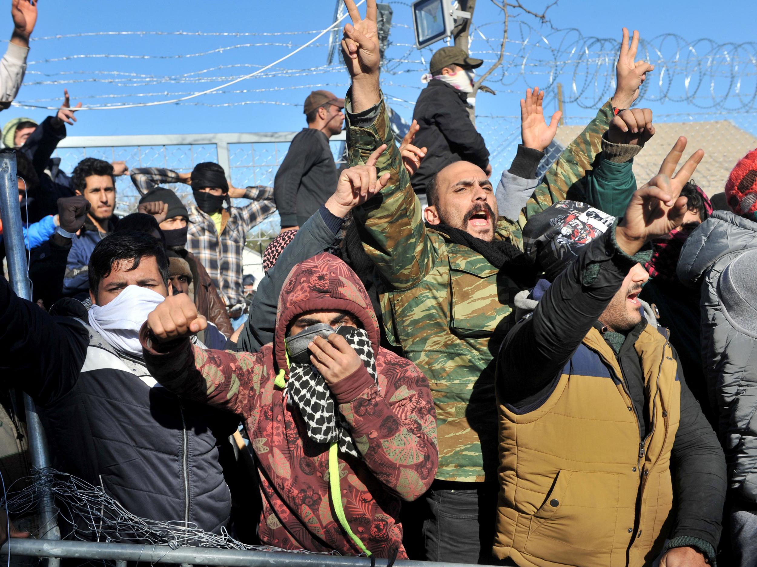 Refugees flash the 'V for victory' sign during a demonstration as they block the Greek-Macedonian border Getty